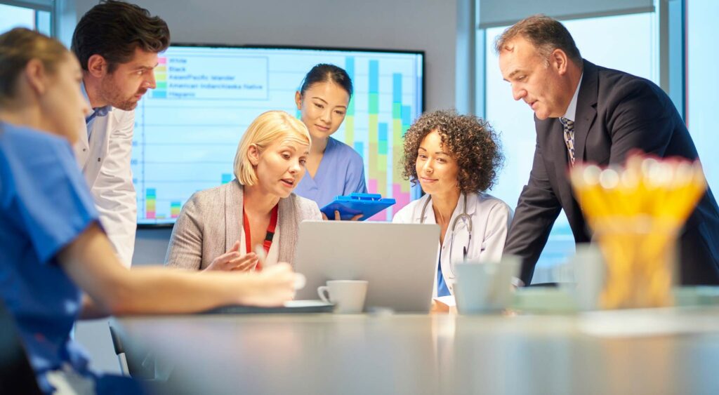 Team meeting around a laptop in an office