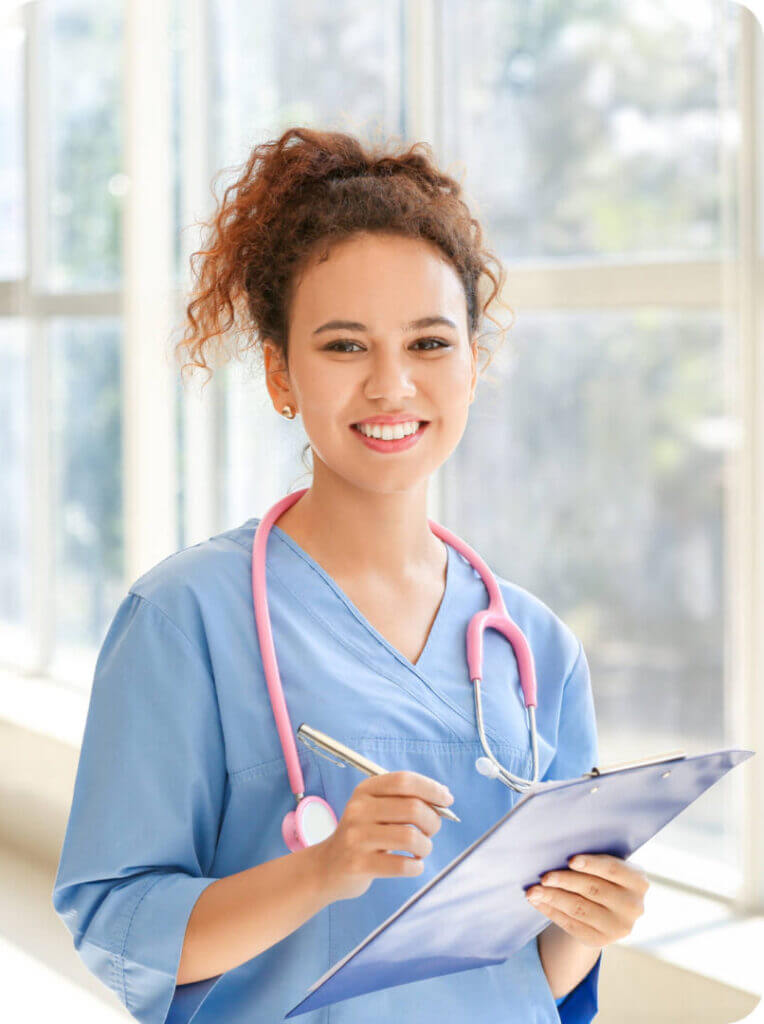 Travel nurse in scrubs holding a patient chart in a hospital