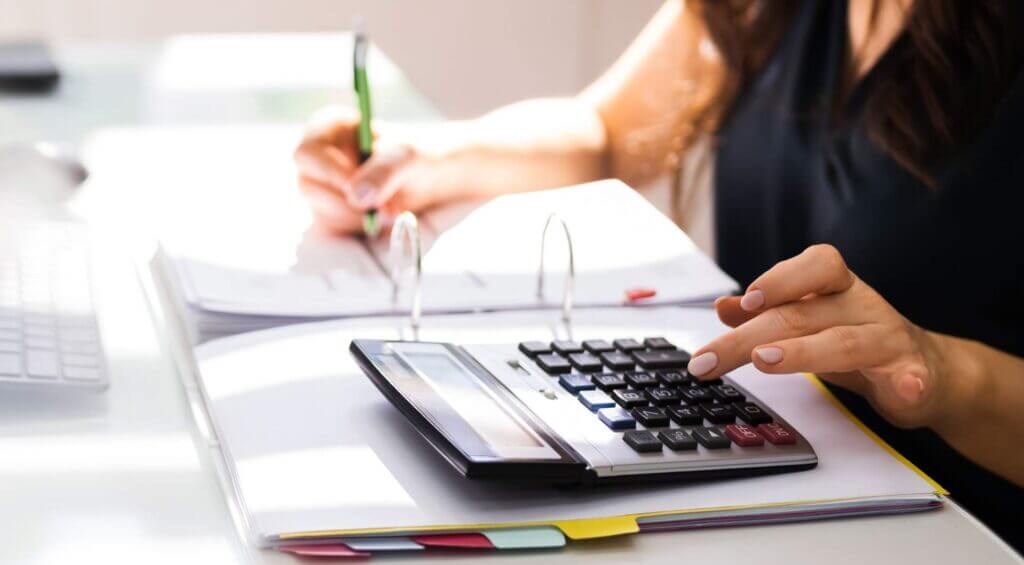 Hands using a calculator over tax paperwork